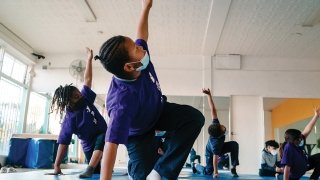 Sylinda (left) and Aja (right) participate in a yoga class during after-school programming at the Crenshaw Family YMCA.