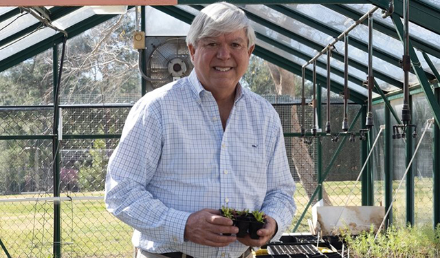 Knight checks on seedlings in the greenhouse at Oak Hills Elementary School