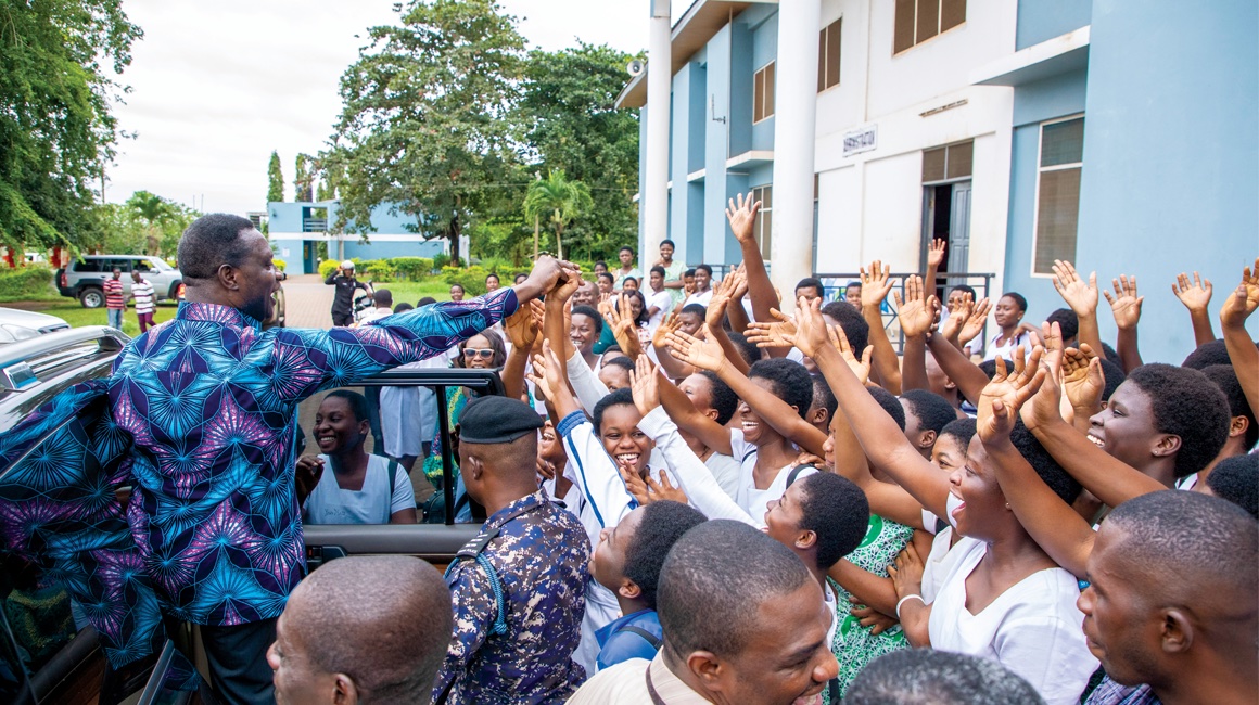 Yaw Osei Adutwum PhD ’09, Ghana’s Minister of Education greets students outside of Afia Kobi Ampen Senior High School.