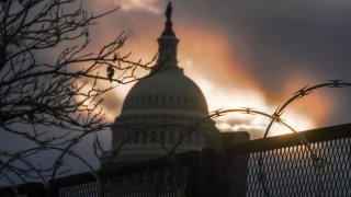 Razor wire and fences surround the U.S. Capitol building at sunrise a few days after the Capitol was breached during an insurrection on Jan. 6. (Photo/Associated Press, Jeremy Hogan)