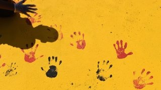 A child adds his handprint to a Black Lives Matter mural along Colfax Avenue, in front of Benton Harbor High School, in Benton Harbor, Michigan. (Photo/AP Images, Don Campbell/The Herald-Palladium)