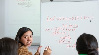 A teacher shows an example of long division on a white board as California tries to close the achievement gap in math