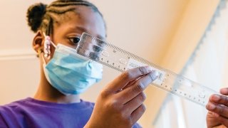 Crenshaw-Family-YMCA-student-and-ruler-800.jpg A student studies a ruler