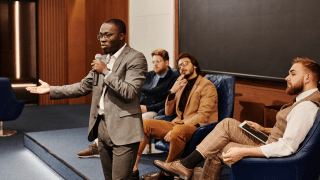 Photo of a man speaking in a lecture hall.