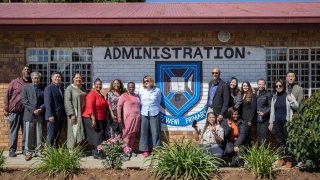 Students in USC Rossier's Global EdD program and professor Alan Green pose for a photo outside of  Dumezweni Elementary School in Soweto, South Africa.