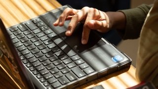Student typing on a laptop.