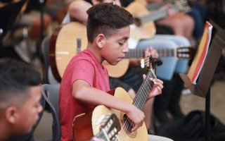 A student plays a guitar. 