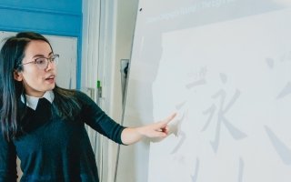 A teacher points to Chinese characters during a Mandarin class.