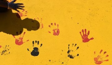 A child adds his handprint to a Black Lives Matter mural along Colfax Avenue, in front of Benton Harbor High School, in Benton Harbor, Michigan. (Photo/AP Images, Don Campbell/The Herald-Palladium)