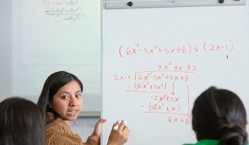 A teacher shows an example of long division on a white board as California tries to close the achievement gap in math