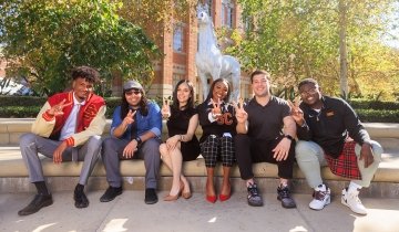 The inaugural class of USC Rossier’s new Teacher Preparation Residency program in front of the Traveler statue at USC’s University Park Campus. Back row, left to right: Elijah Chesley BA ’21 and Joseph Arechiga; front row, left to right: Ramiro Alexander-Duchesne BA ’ 17, Jamie Roman Nunez, Lauryn Merriweather and Derringer Dillingham