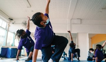 Sylinda (left) and Aja (right) participate in a yoga class during after-school programming at the Crenshaw Family YMCA.