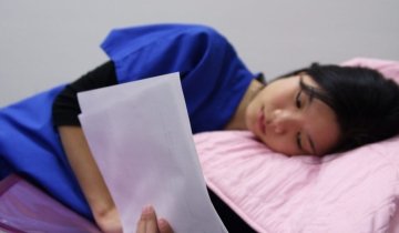 A student reads in bed.