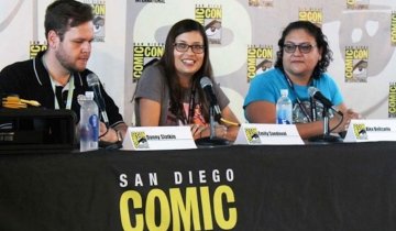 Emily Sandoval smiling and talking on the mic at Comic-Con, encouraging people to embrace their inner geek.