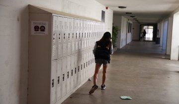 A young girl walking alone in the school corridor.
