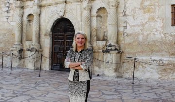 Kate Rodgers stands in front of the Alamo.