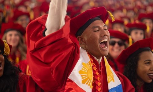 A doctoral graduate celebrates at USC Rossier's 2022 Commencement.