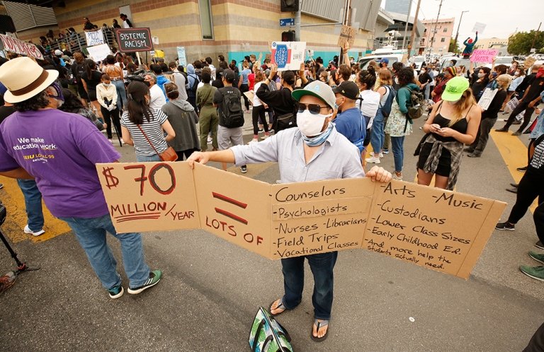 Students, teachers and community members marched to LAUSD headquarters this summer to urge the district to defund school police. (Photo/ Getty Images, Al Seib)