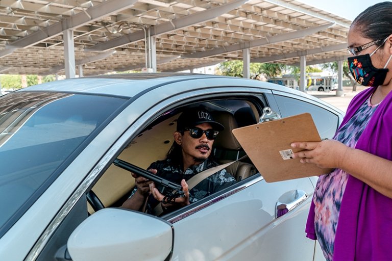 Rommel Lopez picks up a Chromebook for his youngest son. The family has a laptop at home, but Rommel's oldest son needs it for college work. (Photo/Rebecca Aranda)