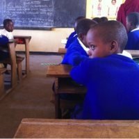 Maasai families provide benches for children in school.