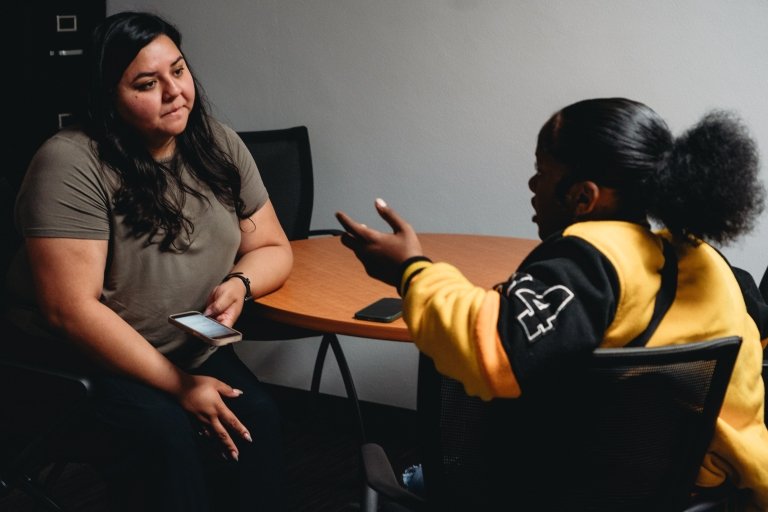 Govea speaks with a student in the program during a classroom session.