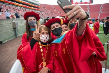 USC President Carol L. Folt takes a photo with graduates