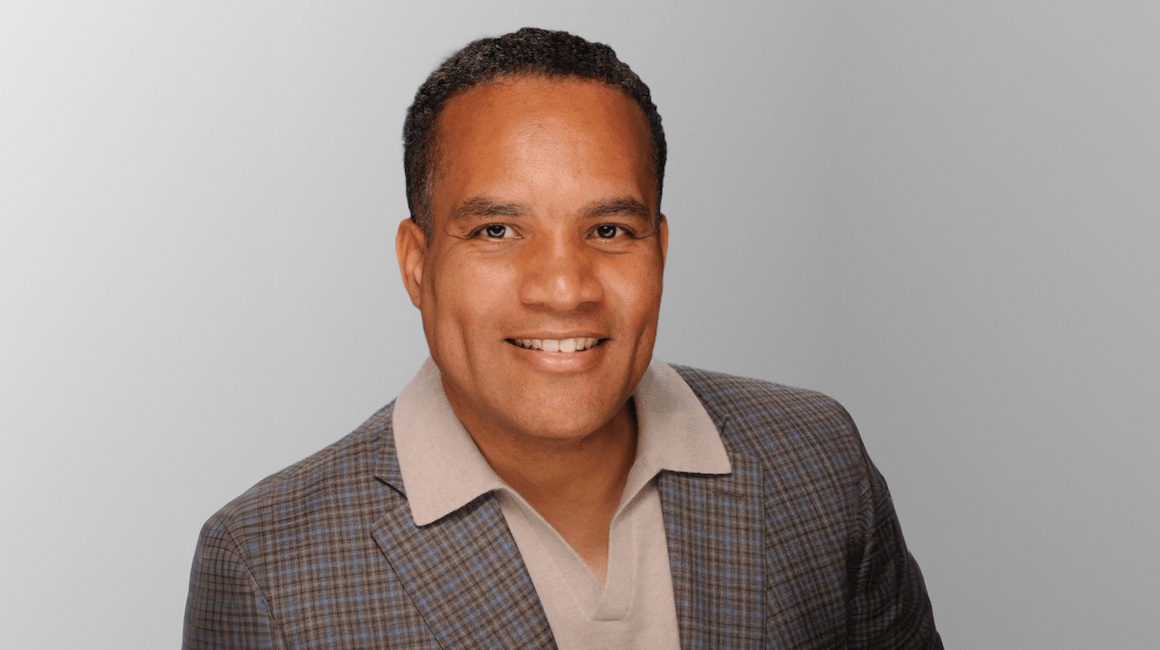 Headshot portrait of Darin Brawley smiling in a plaid blazer