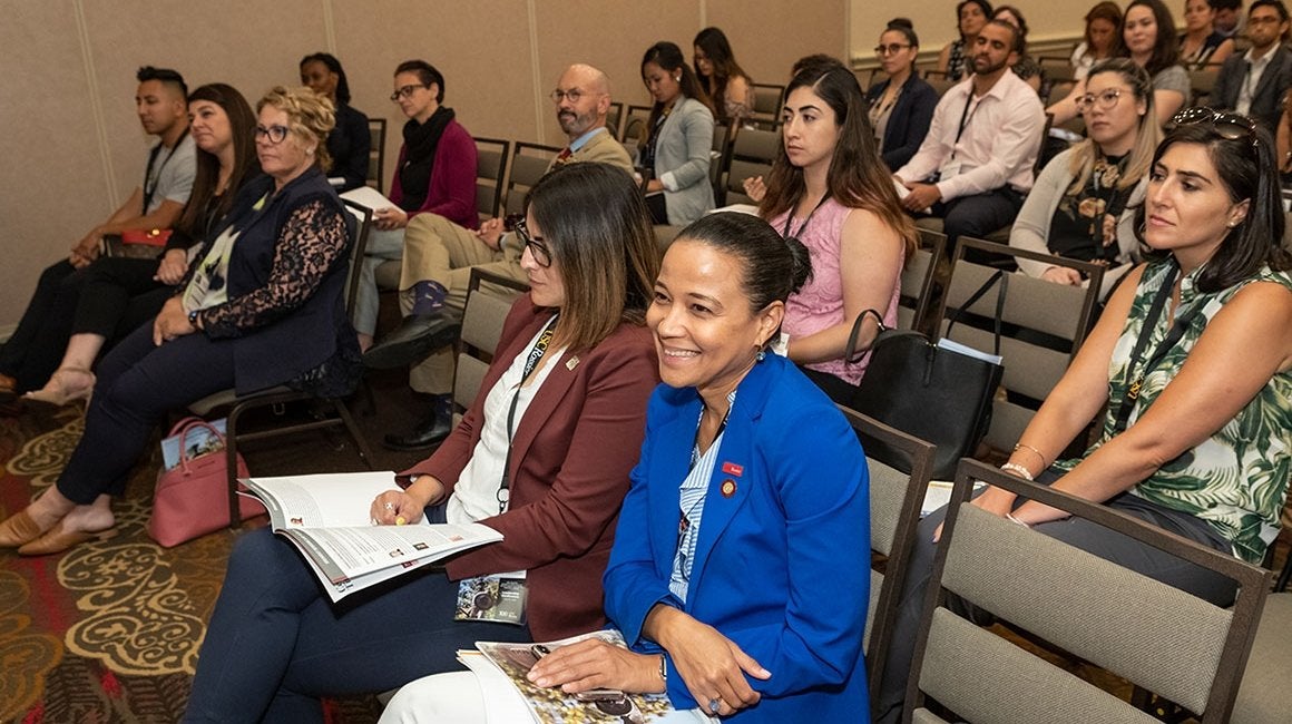 Attendees seated together smiling at a leadership conference