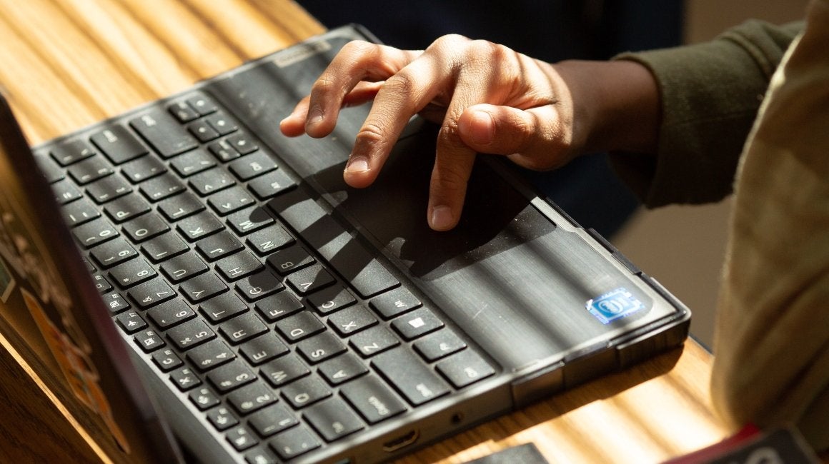 Close-up of a hand using a laptop touchpad