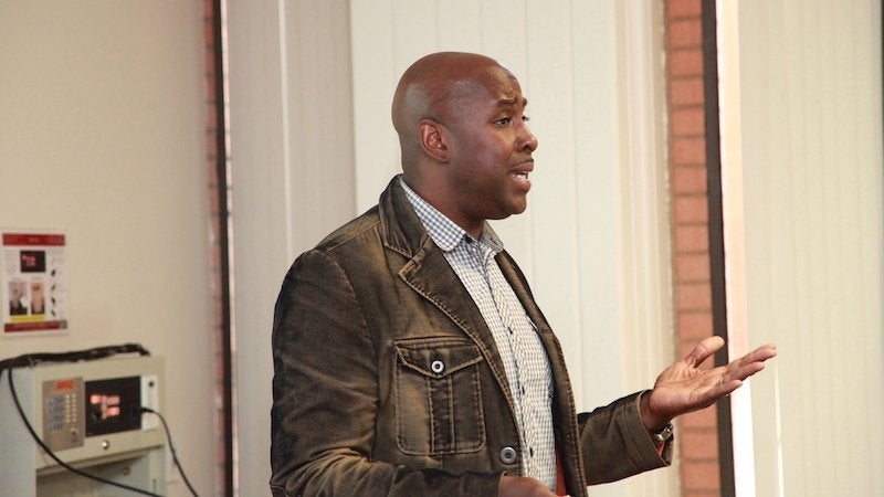 Darnell Cole gesturing while teaching in front of a classroom
