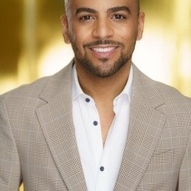 Headshot portrait of Johnson smiling in a plaid blazer