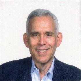 Headshot portrait of Richard Grad smiling in a navy blazer