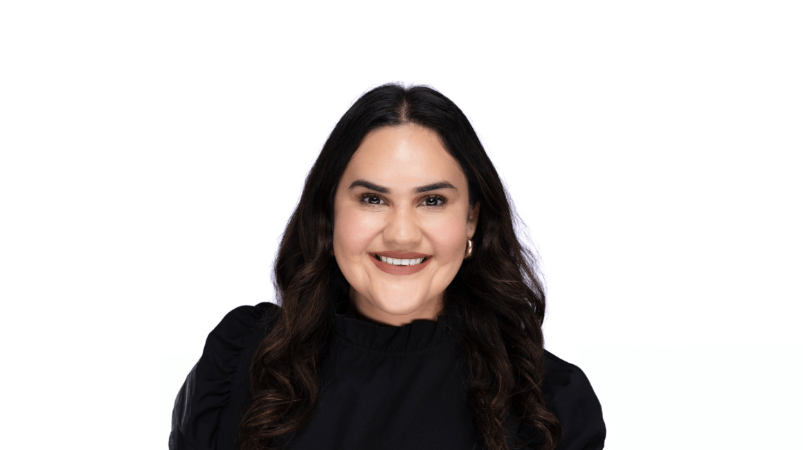 Headshot portrait of Rochelle Espitia smiling in a black top