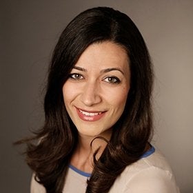 Headshot portrait of Samkian smiling in a cream top