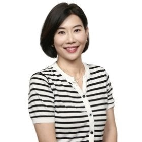 Headshot portrait of Emmy Min smiling in a striped cardigan