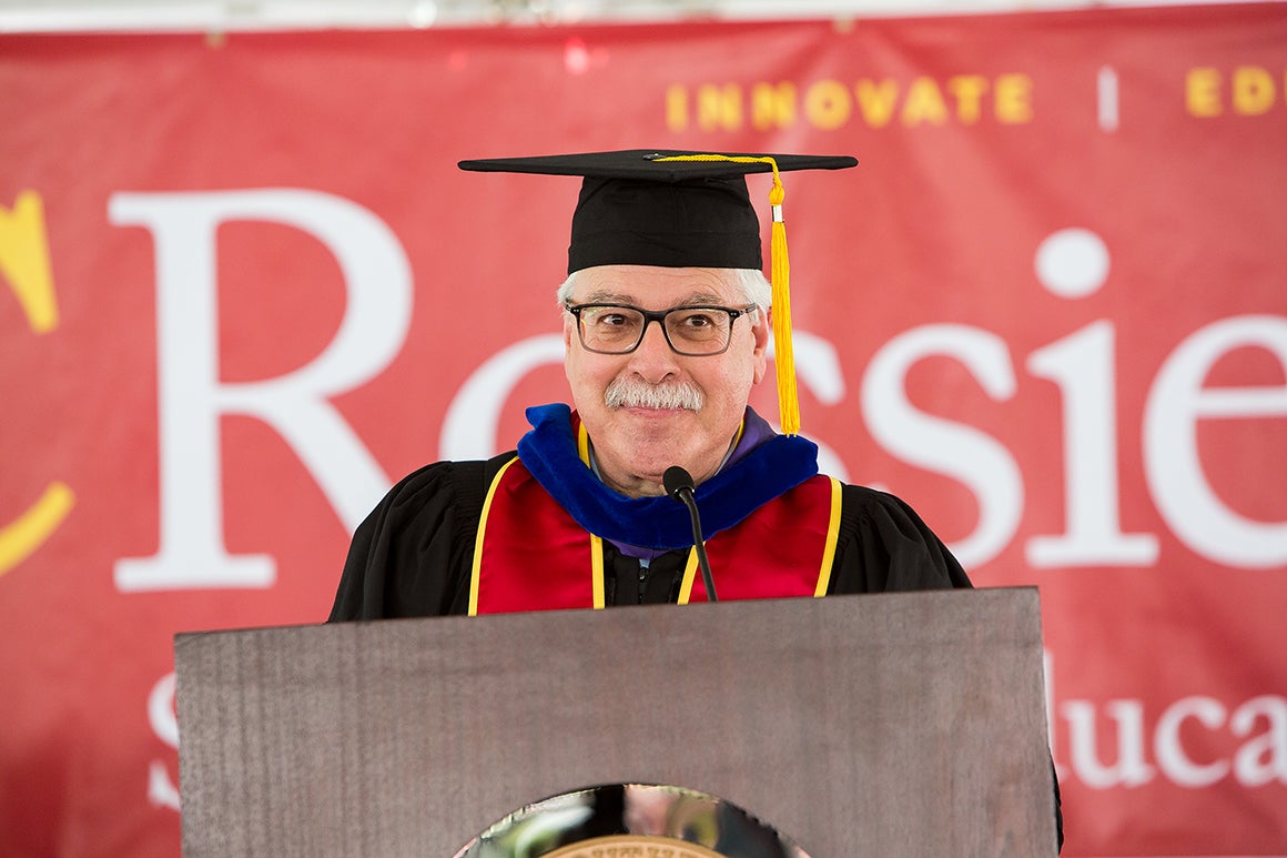 Man speaking at podium during a USC Rossier doctoral commencement