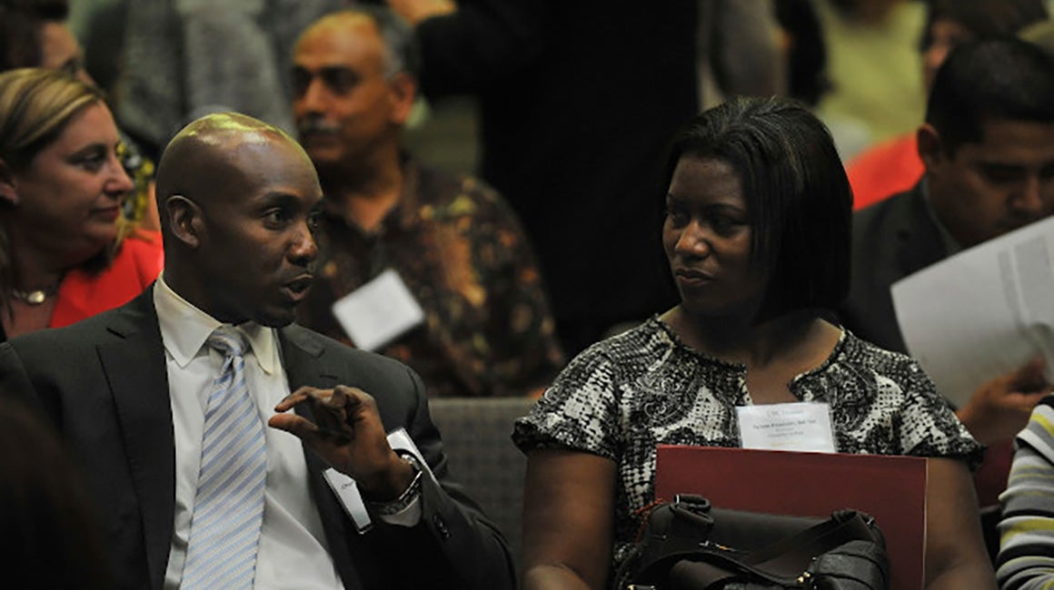 Man in uniform speaking with a woman at an event