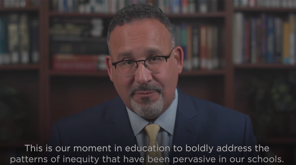 Speaker addressing inequities in schools at an education summit