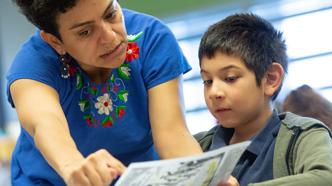 Woman and boy reading a book together