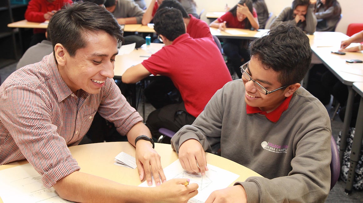 Two men reviewing documents together, discussing educational equity