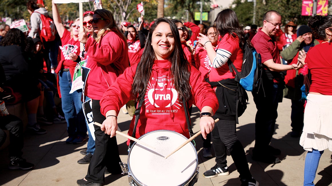 Protesters marching with a drum during a rally