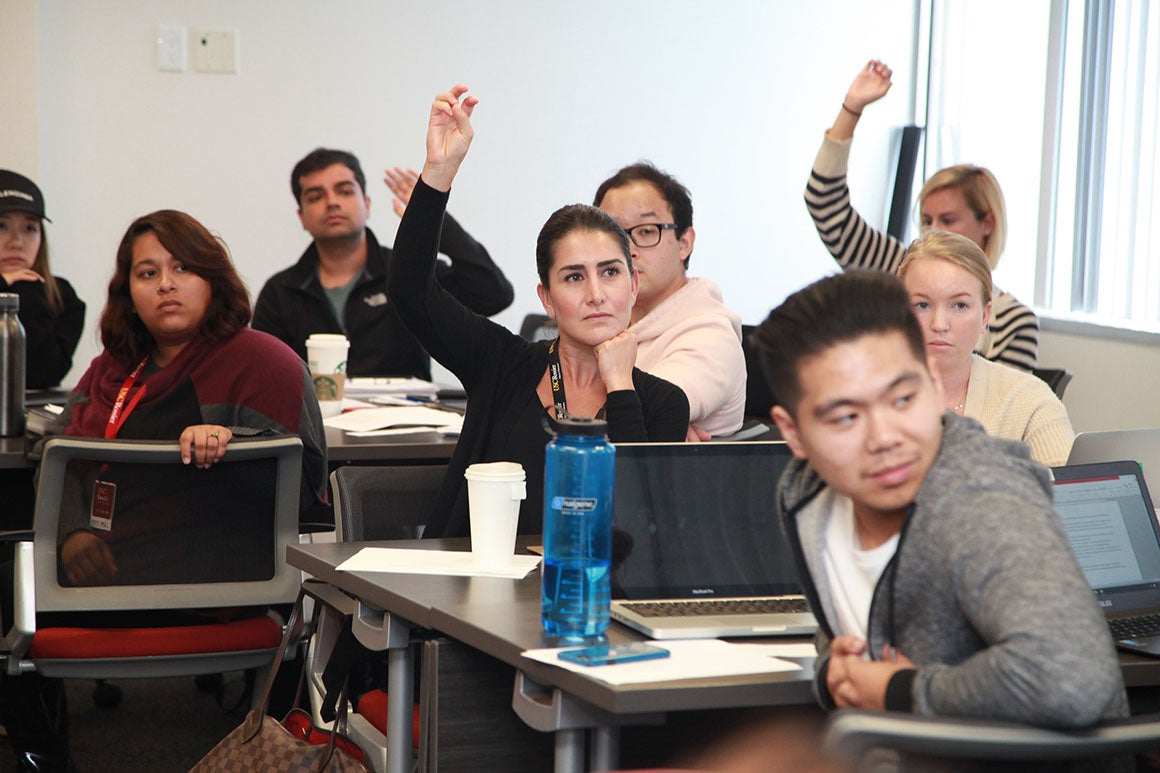 Students raising hands during a classroom discussion