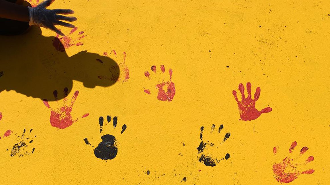 Handprints in orange paint on the floor