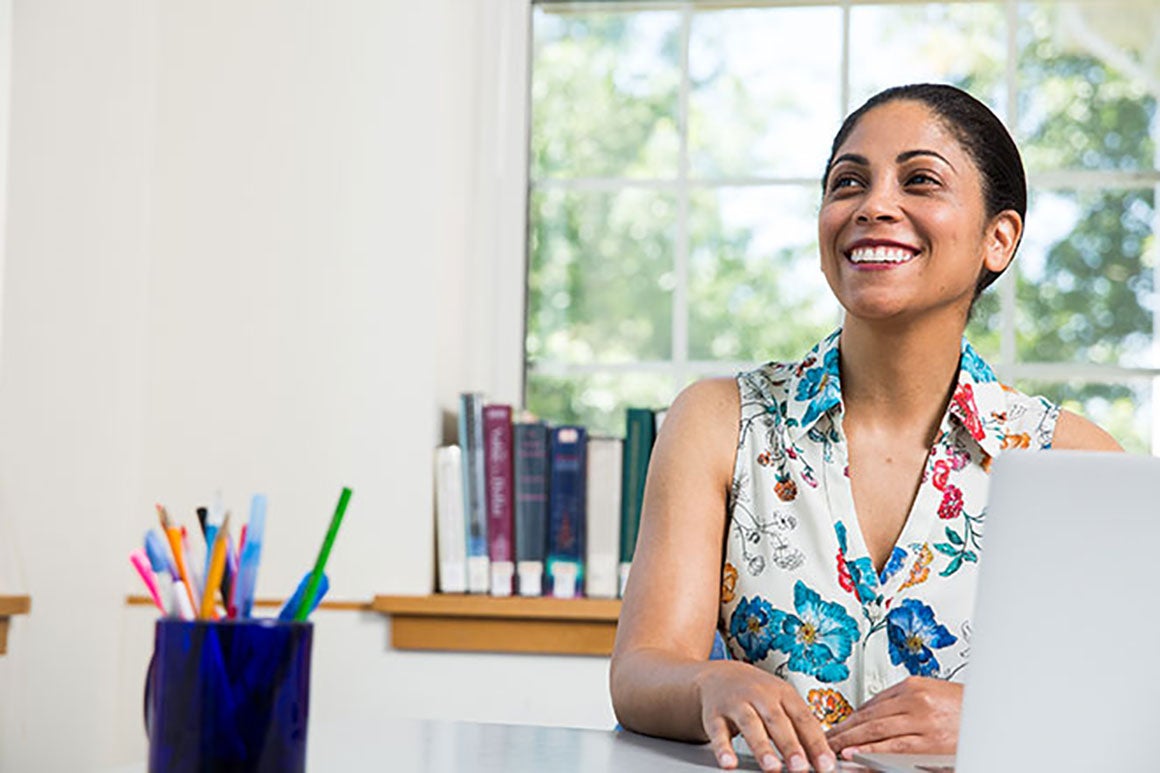 Woman smiling while sitting at her desk