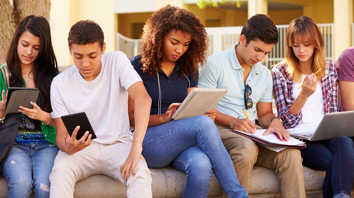 Group of students sitting together looking at a phone