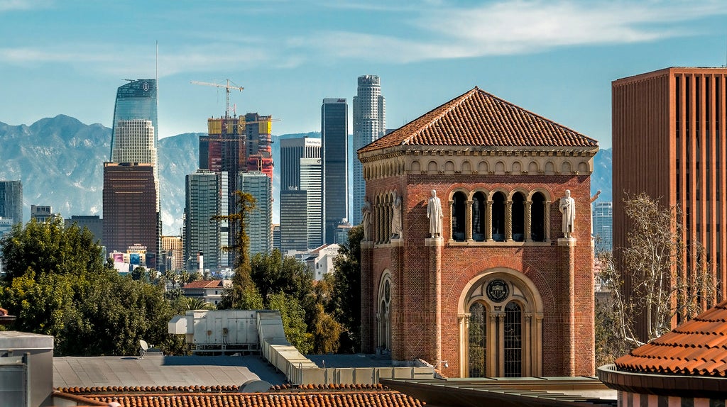 USC campus building with the downtown Los Angeles skyline in the background